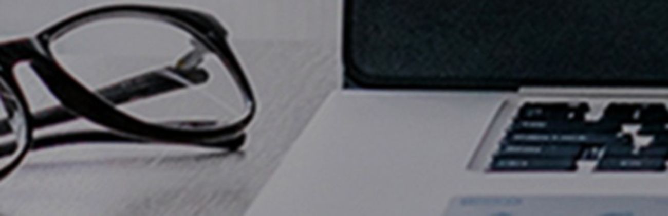 Ein Laptop und eine Brille auf einem Tisch